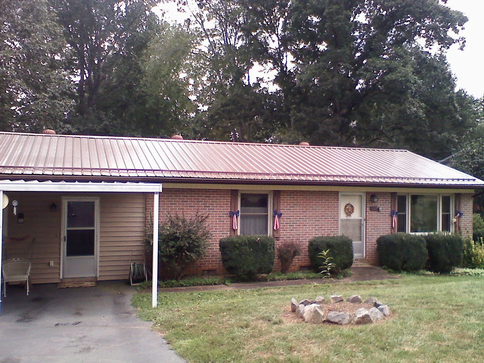 Bronze metal roof and carport on a brick ranch home — Roof Repair work by our crew in Kingman